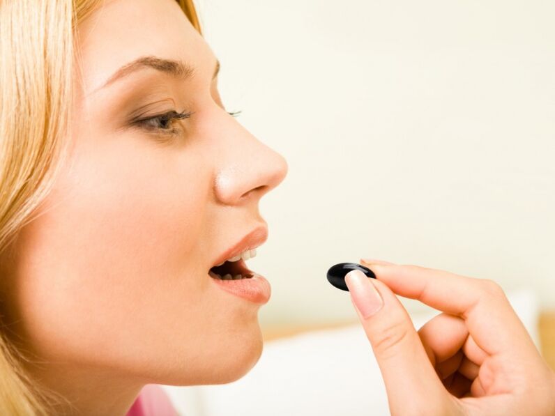 menina toma um comprimido para prevenir vermes